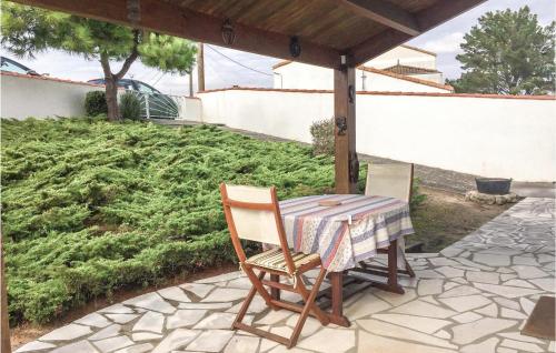 a table and chair sitting on a patio at Two-Bedroom Holiday Home In La Tranche-Sur-Mer in La Tranche-sur-Mer