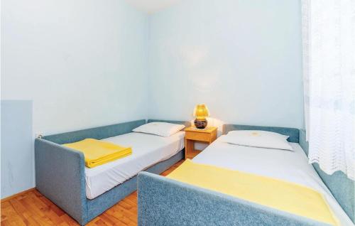a room with two beds and a blue couch at Stunning Apartment In Crikvenica With Wifi in Crikvenica