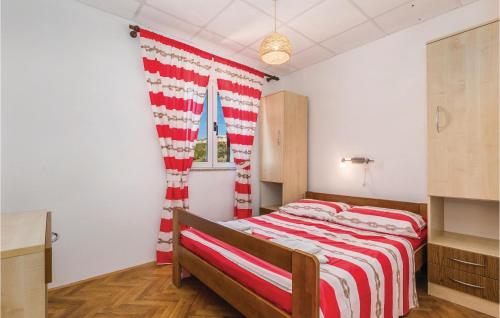 1 dormitorio con 1 cama con manta roja y blanca en Awesome Apartment In Dinjiska With 1 Bedrooms And Wifi en Dinjiška