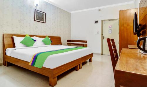 a bedroom with a bed and a desk in a room at Treebo The Grand Skyla Marathahalli in Bengaluru