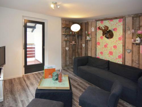 ein Wohnzimmer mit einem Sofa und einem Tisch in der Unterkunft Modern holiday home in Hessen with private terrace in Trubenhausen