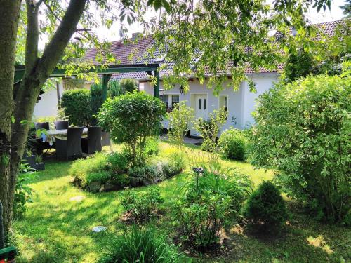 a garden in front of a white house at Spacious Holiday Home in Sommerfeld near Lake in Kremmen