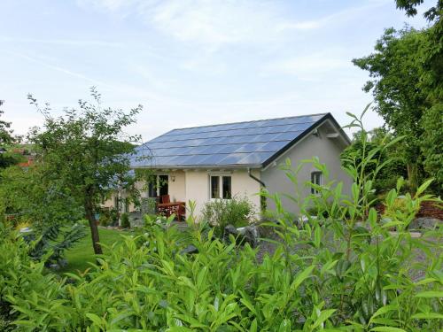 ein Haus mit Sonnenkollektoren auf dem Dach in der Unterkunft Cozy Holiday Home in Willersdorf with Pond in Frankenberg