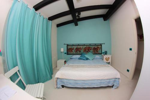 a bedroom with a large bed with blue curtains at B&B I Fiori del Mare in Agropoli