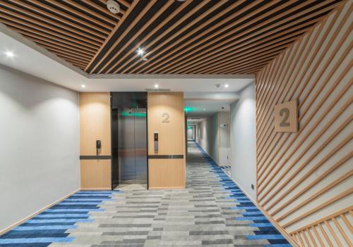 a hallway of a building with two elevators at Holiday Inn Express Shanghai Gubei by IHG in Shanghai