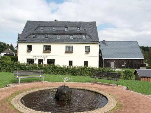 un bâtiment avec une fontaine en face d'un bâtiment dans l'établissement Spacious holiday home in the Ore Mountains, à Deutschneudorf