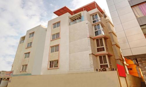 a tall white building with a red roof at Treebo The Grand Skyla Marathahalli in Bengaluru