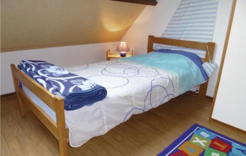 ein kleines Schlafzimmer mit einem Bett mit einer blauen Decke darauf in der Unterkunft 2 Bedroom Amazing Home In Anneville Sur Mer in Anneville-sur-Mer