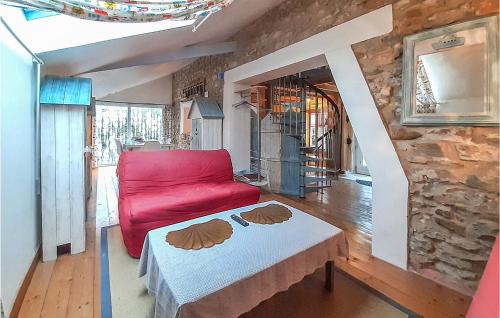 a living room with a red couch and a table at Cozy Home In Ambleteuse With Wifi in Ambleteuse