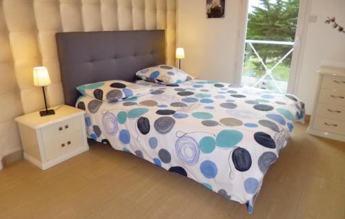 a bedroom with a bed with a polka dot bedspread at Awesome Home In St,germain-ay-plage With 3 Bedrooms And Wifi in Saint-Germain-sur-Ay