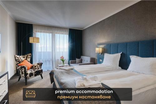 ein Hotelzimmer mit einem großen Bett und einem Stuhl in der Unterkunft SPA Resort St Ivan Rilski - Halfboard & All Inclusive in Bansko