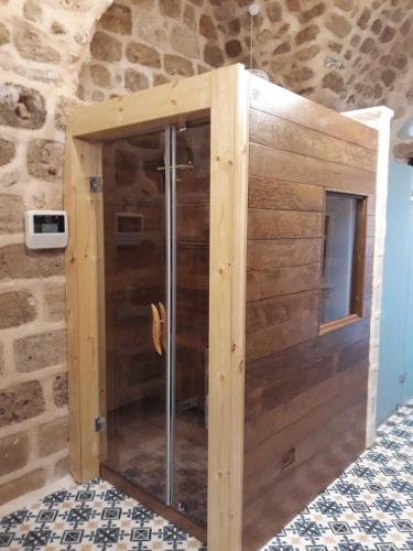 a shower stall in a room with a stone wall at Akka in ‘Akko