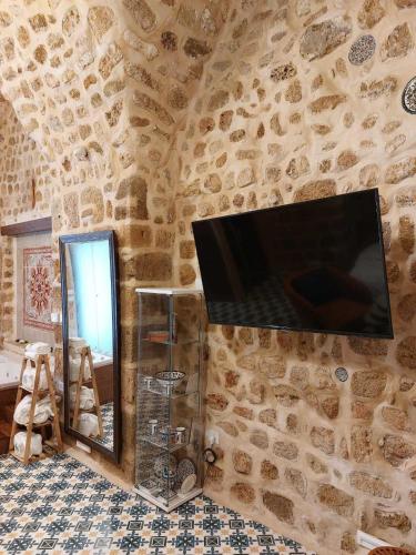 a wall with a tv on a stone wall at Akka in ‘Akko