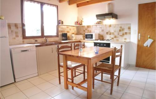 a kitchen with a wooden table and chairs in it at Three-Bedroom Holiday Home In La Tranche Sur Mer in La Tranche-sur-Mer
