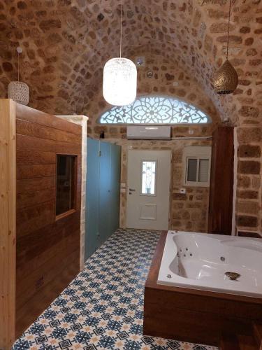 a large bathroom with a tub and a window at Akka in ‘Akko