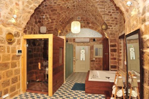 a bathroom with a tub in a stone wall at Akka in ‘Akko