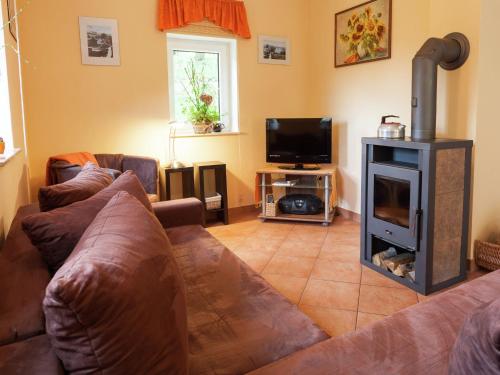 a living room with a couch and a fireplace at Charming Holiday Home in Hohnstein ot Lohsdorf in Hohnstein