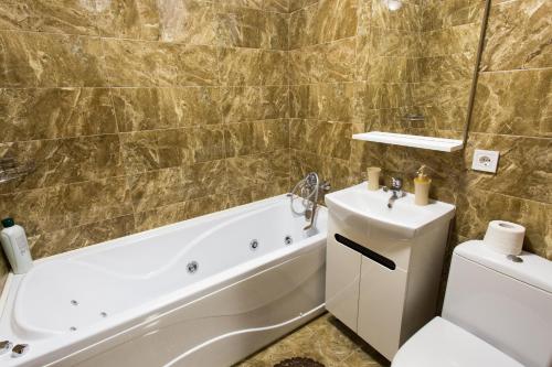a bathroom with a tub and a toilet and a sink at Luxury One bedrooms 23 August in Kharkiv
