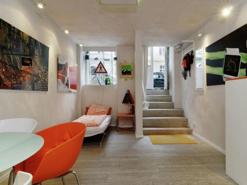 sala de estar con silla naranja y escalera en Apartment in Kreuzberg with internet, en Berlín