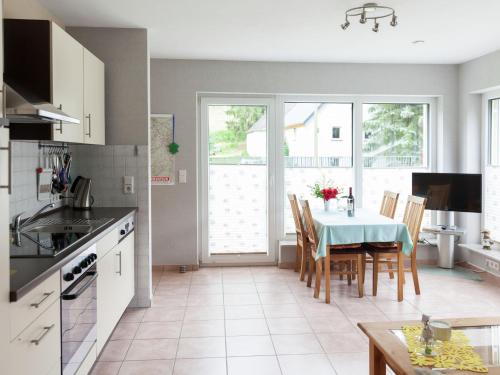 a kitchen and dining room with a table and chairs at Apartment with terrace and view in Merschbach