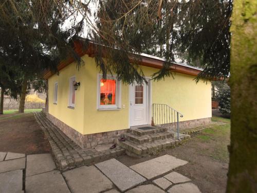 ein kleines gelbes Haus mit einem Fenster und einer Treppe in der Unterkunft Vintage Holiday Home in Trieb with Terrace in Trieb