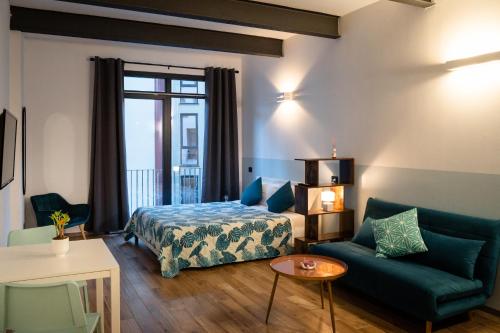 ein Schlafzimmer mit einem Bett, einem Sofa und einem Tisch in der Unterkunft OLD GENOA SUITES in Genua