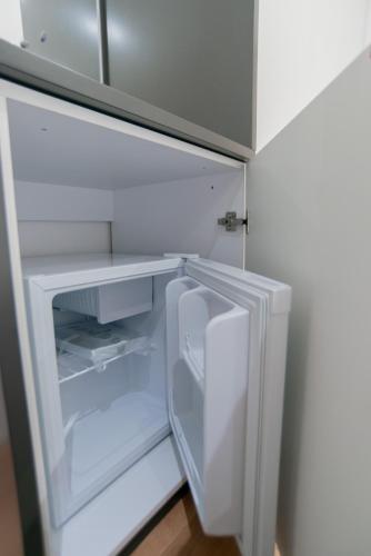 an empty refrigerator with its door open in a kitchen at La Gioia Apartment in Tirana