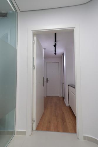a hallway with white walls and a glass door at La Gioia Apartment in Tirana