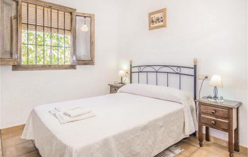 biała sypialnia z łóżkiem i oknem w obiekcie Lovely Home In Iznájar w mieście Villanueva de Tapia
