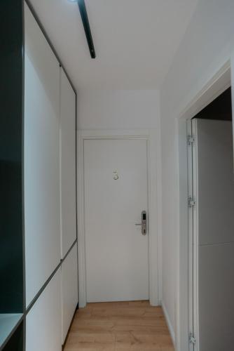 a hallway with a white door and a mirror at La Gioia Apartment in Tirana