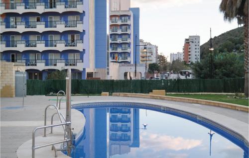 basen przed wysokim budynkiem w obiekcie Cozy Apartment In Fuengirola With Wifi w mieście Fuengirola