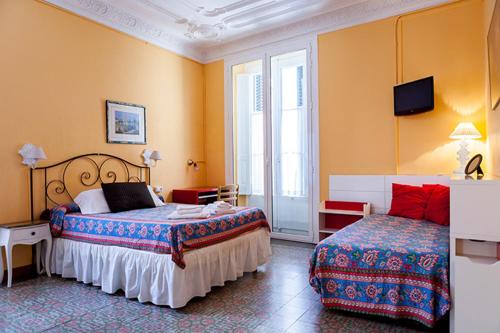 a hotel room with two beds and a window at Hostal del Palau in Barcelona