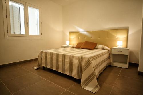 Case Vacanza Viola di Mare في كوستوناتشي: غرفة نوم مع سرير مع مواقف ليلتين ونافذة