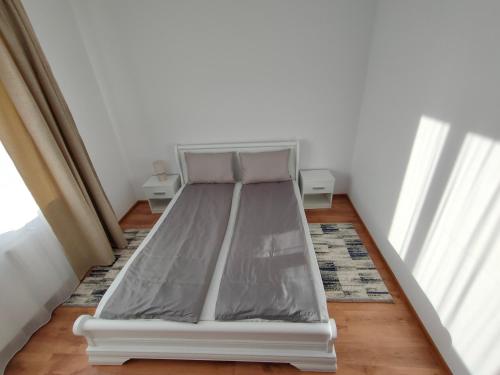 a bed sitting in a room next to a window at Fanea Residence in Timişoara