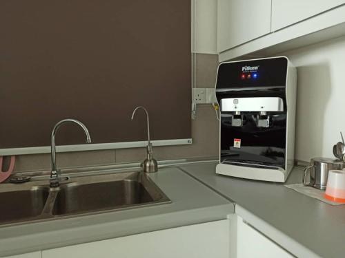 a kitchen with a sink and a coffee machine at Meritus Apartment in Perai