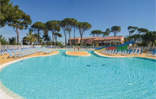 une grande piscine avec des chaises et un toboggan dans l'établissement Cozy Home In Calvisson With Kitchen, à Calvisson
