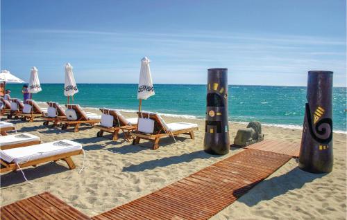une plage avec des chaises et des parasols et l'océan dans l'établissement Les Pierres De Jade, à Saint Cyprien Plage