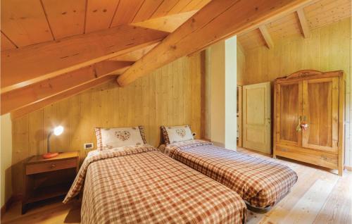 2 Betten in einem Zimmer mit Holzwänden in der Unterkunft Pian Del Lac in Sovramonte