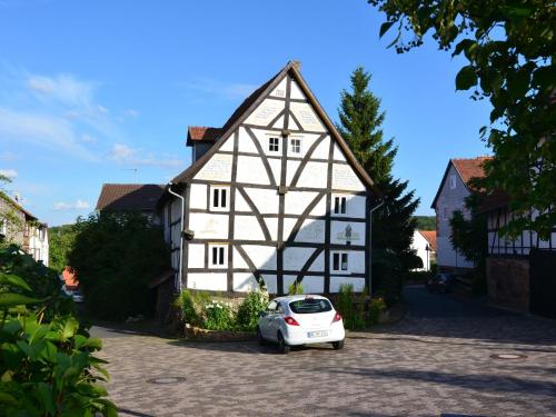 a white car parked in front of a building at Holiday home in Hesse with garden in Willingshausen