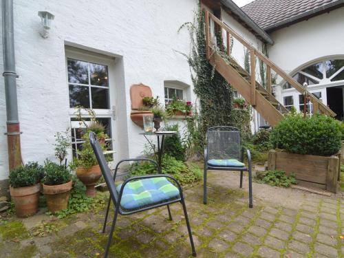 a pair of chairs sitting outside of a house at Romantic Eifel Hideaway in Immerath