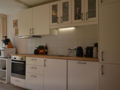 eine Küche mit weißen Schränken und einem Waschbecken in der Unterkunft Holiday home in nice surrounding in Veldenz