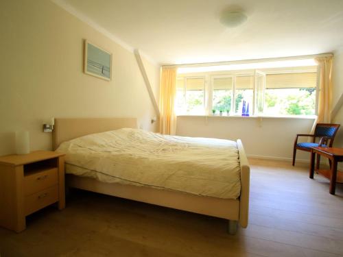 Schlafzimmer mit einem Bett, einem Tisch und einem Fenster in der Unterkunft Holiday home in nice surrounding in Veldenz