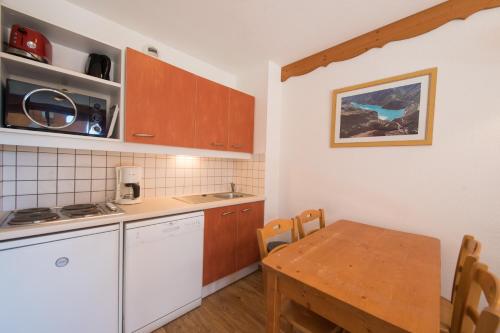 une cuisine avec une table et une salle à manger dans l'établissement le hameau des ecrins, à Puy-Saint-Vincent