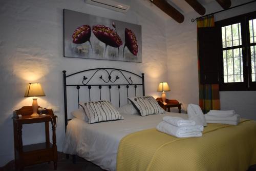 1 dormitorio con 1 cama con toallas en Finca Ventorrillo Competa en Cómpeta