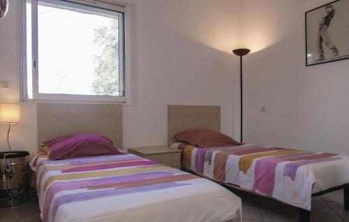 two beds in a room with a window at Amazing Apartment In Oletta With Kitchen in Oletta