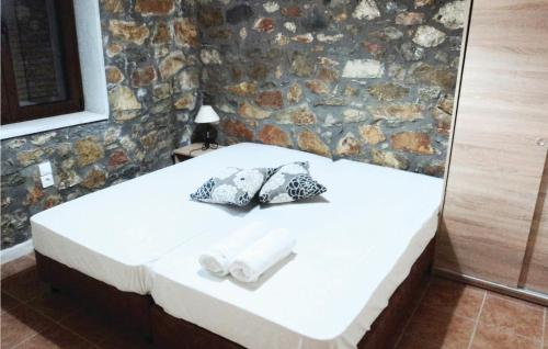 a bed in a room with a stone wall at 3 Bedroom Lovely Home In Paralio Astros in Koútroufa