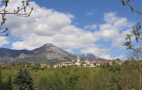 une ville sur une colline avec une montagne en arrière-plan dans l'établissement Lovely Apartment In St Bonnet En Champsaur, à Saint-Bonnet-en-Champsaur