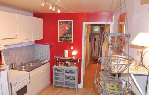 d'une cuisine avec des murs rouges, un évier et un comptoir. dans l'établissement Lovely Apartment In St Bonnet En Champsaur, à Saint-Bonnet-en-Champsaur