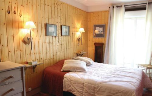 a bedroom with a bed with wooden walls and a window at 2 Bedroom Lovely Apartment In St Bonnet En Champsaur in Saint-Bonnet-en-Champsaur