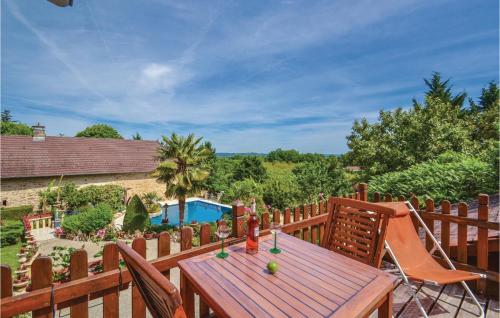 une terrasse en bois avec une table et des chaises en bois dans l'établissement Nice Apartment In Terrasson With Wifi, à La Talerie